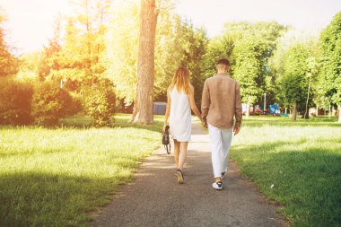 Adam ve kadın parkta yürüyorlar.