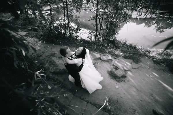 Beautiful wedding couple hugging in the park — Stock Photo, Image