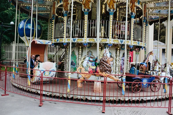 Volwassen man en vrouw op een carrousel — Stockfoto