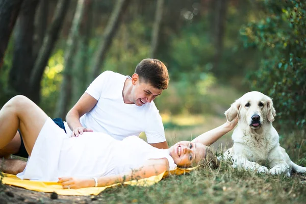 Gravid kvinna med man liggande i parken — Stockfoto