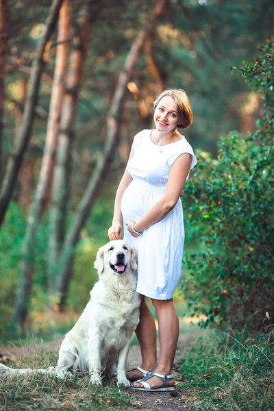 Hermosa mujer embarazada y su perro — Foto de Stock