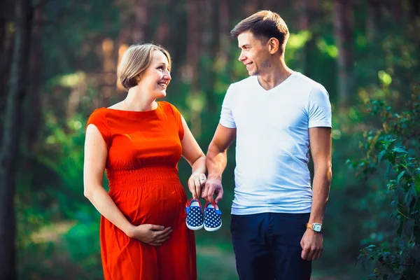 Terhes feleség, és férje gazdaság baba cipő — Stock Fotó