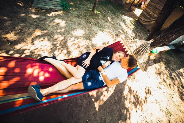 Pregnant woman and husband, resting in a hammock — Stock Photo, Image