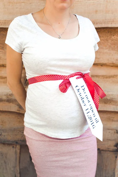 Dziewczyna w ciąży na podłoże drewniane ściany — Zdjęcie stockowe