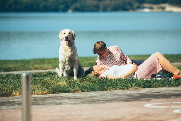 Feliz pareja sonriente relajándose sobre hierba verde — Foto de Stock