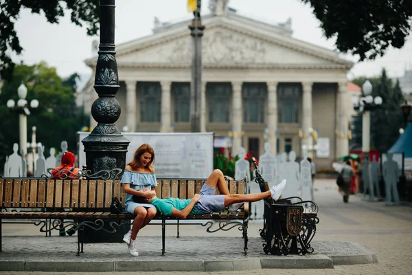 Τύπος και το κορίτσι που κάθεται σε ένα παγκάκι — Φωτογραφία Αρχείου