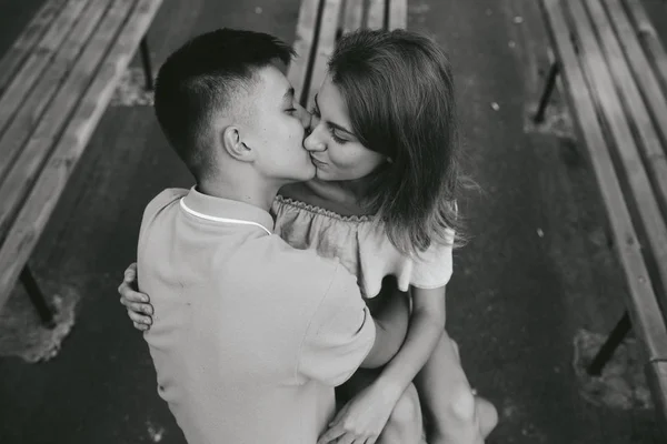 Cara e a menina beijando em um banco — Fotografia de Stock