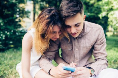 Ascot parkta oturan bir smartphone kullanarak