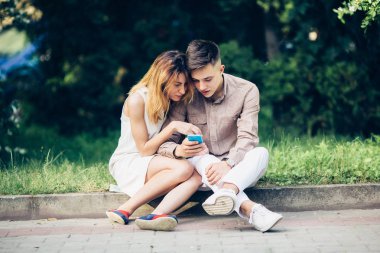 Ascot parkta oturan bir smartphone kullanarak