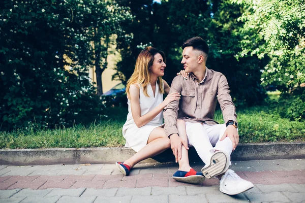 Man and woman sitting on the curb — Stock Photo, Image