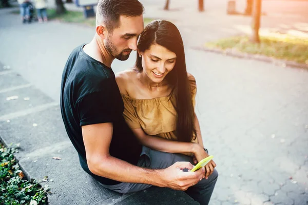 Un cuplu se uită la ceva pe un telefon inteligent — Fotografie, imagine de stoc