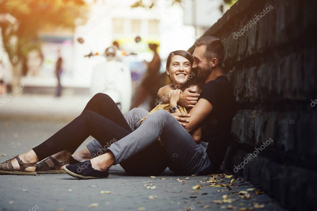 young beautiful couple sitting on the ground