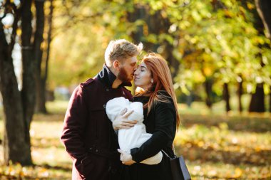 Genç aile ve sonbahar Park yeni doğan oğlu