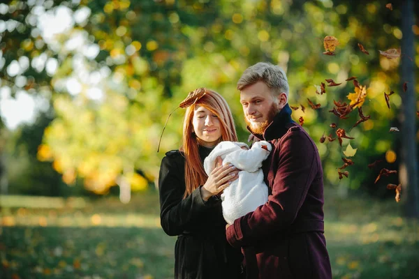 Familia joven e hijo recién nacido en el parque de otoño —  Fotos de Stock