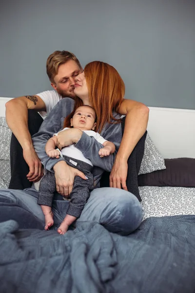 Familia feliz con bebé recién nacido en la cama — Foto de Stock