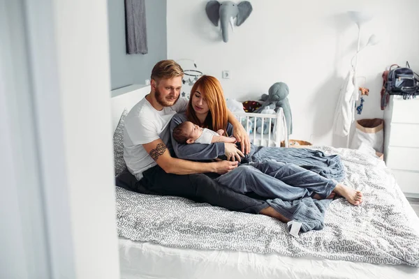 Boldog család újszülött az ágyon — Stock Fotó