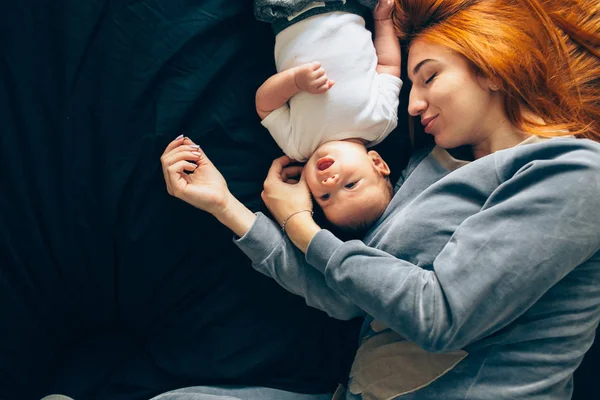 Счастливая мать с ребенком лежит вместе на кровати — стоковое фото