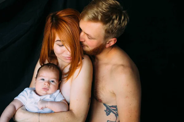 Família feliz em um fundo preto — Fotografia de Stock
