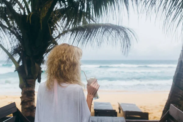 Menina em um banco beber coquetéis — Fotografia de Stock