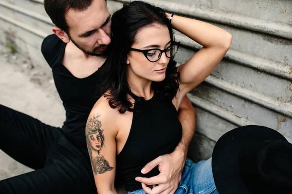 Man en vrouw poseren op een grijze achtergrond muur — Stockfoto