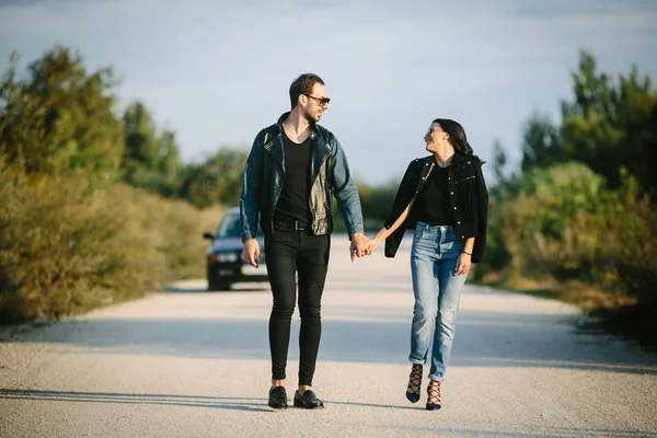 Jonge gelukkige romantisch paar wandelen langs de weg — Stockfoto