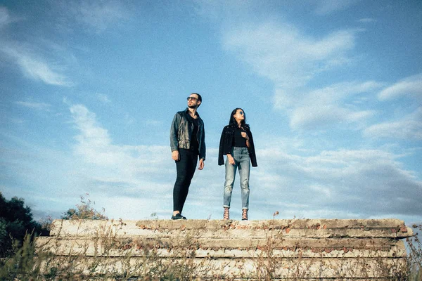 Jovem belo casal posando contra o céu — Fotografia de Stock