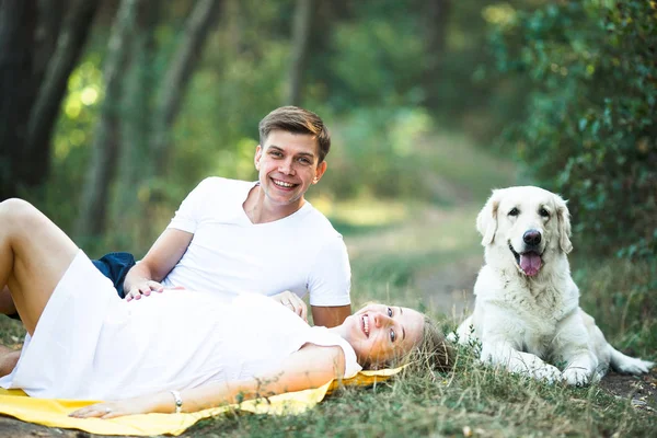 Schwangere mit Mann im Park liegend — Stockfoto