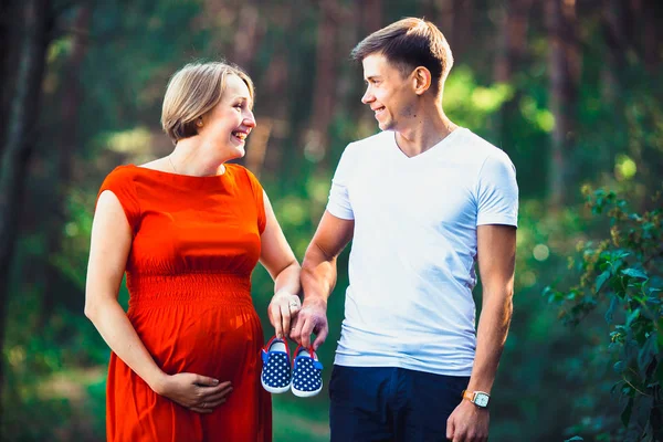 怀孕的妻子和她的丈夫抱着婴儿鞋 — 图库照片