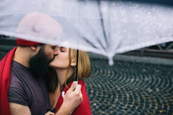 Cara e a menina beijando sob um guarda-chuva — Fotografia de Stock