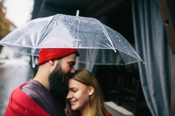 Chico y chica bajo un paraguas — Foto de Stock