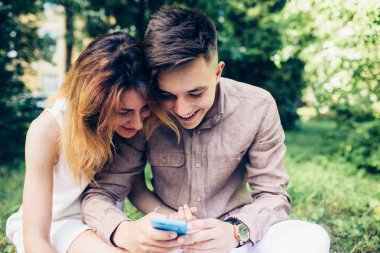 Ascot parkta oturan bir smartphone kullanarak