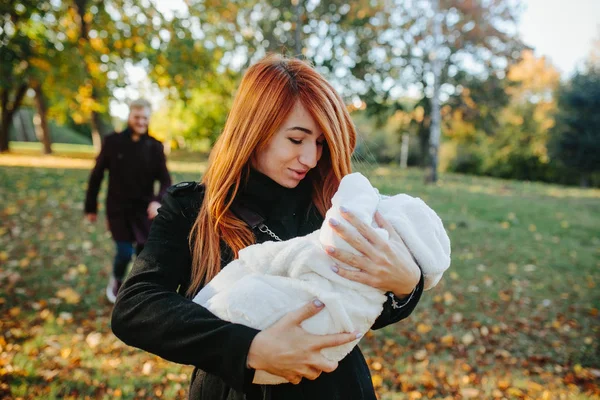 Młode rodziny i nowo narodzonego syna w jesienny park — Zdjęcie stockowe