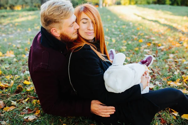 Young family and newborn son in autumn park — Stock Photo, Image