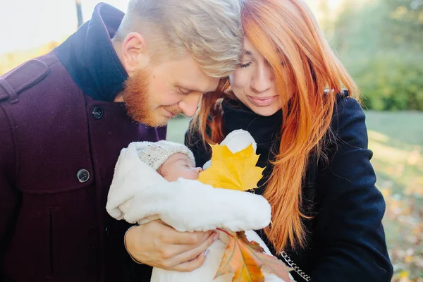 Familia joven e hijo recién nacido en el parque de otoño —  Fotos de Stock