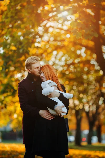 Young family and newborn son in autumn park — Stock Photo, Image