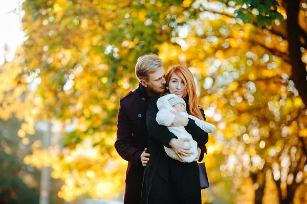 Jong gezin en pasgeboren zoon in herfst park — Stockfoto