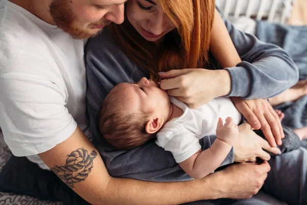 Счастливая семья с новорожденным на кровати — стоковое фото
