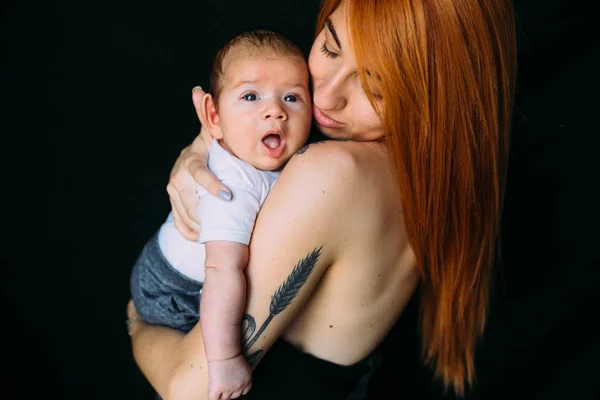 Çocuğunu kucağında tutan genç bir anne. — Stok fotoğraf