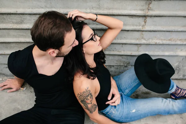 Man and woman posing on a background gray wall — Stock Photo, Image