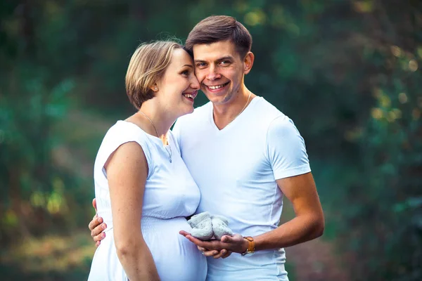 Těhotná žena a její manžel v parku — Stock fotografie