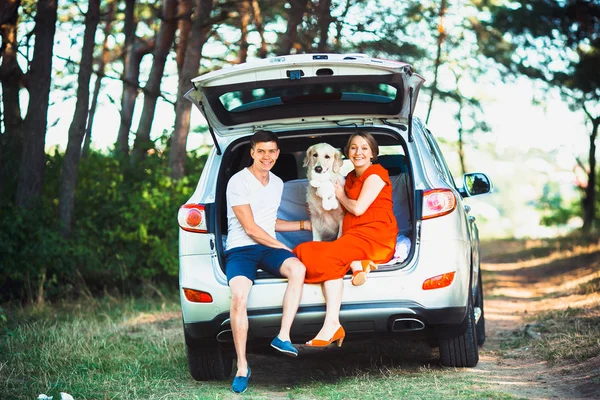Moglie incinta, marito e cane seduti in macchina — Foto Stock