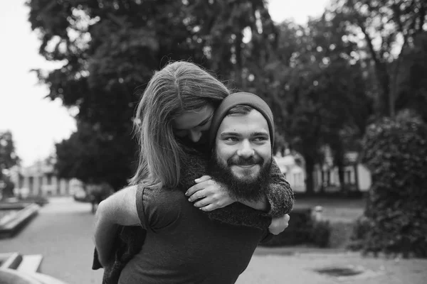Мужчина носит свою девушку на спине — стоковое фото