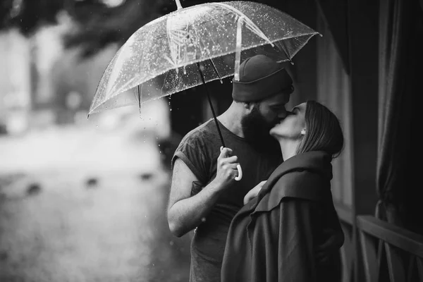 Cara e a menina beijando sob um guarda-chuva — Fotografia de Stock