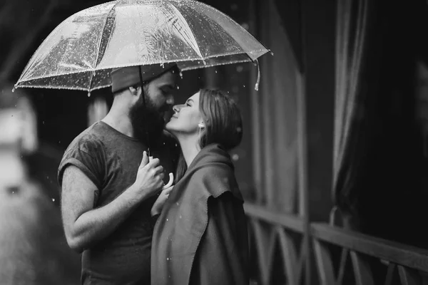 Cara e a menina beijando sob um guarda-chuva — Fotografia de Stock