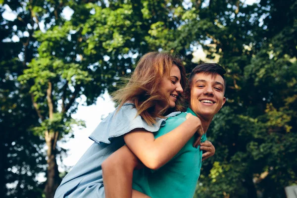 Homem carrega uma menina em suas costas — Fotografia de Stock