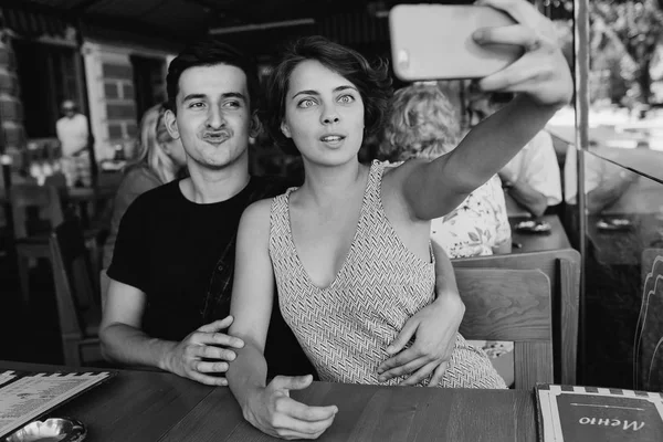 Erkek ve kız dışarıdaki kafede selfie çekiyorlar.