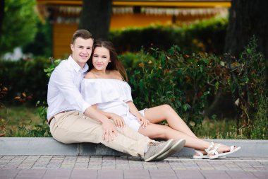 kaldırım kenarında oturan kadın ve erkek