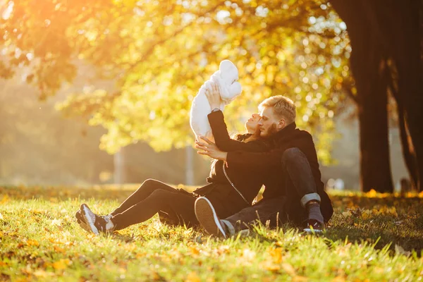 Young family and newborn son in autumn park — Stock Photo, Image