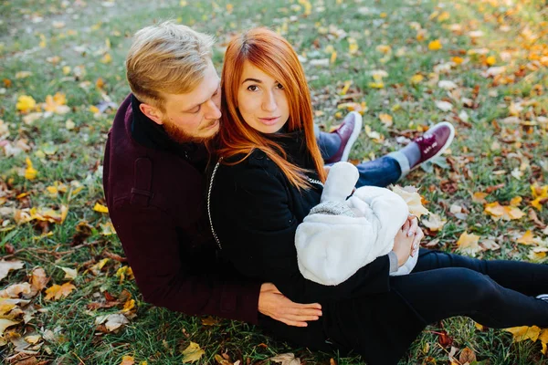 Familia joven e hijo recién nacido en el parque de otoño —  Fotos de Stock