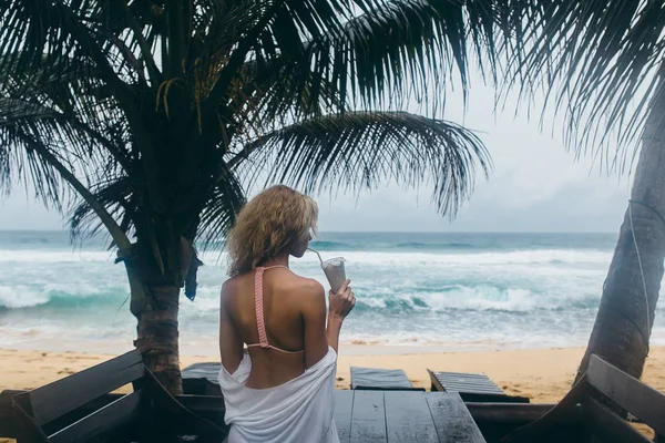 Menina em um banco beber coquetéis — Fotografia de Stock